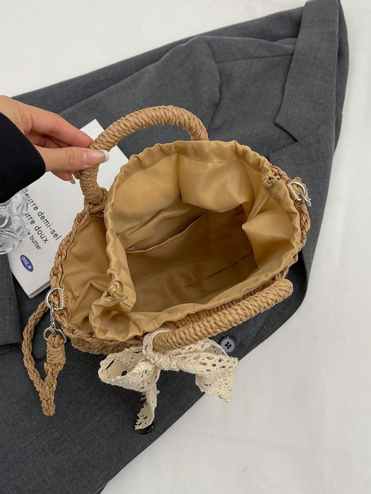Sommertaske i beige på træbord i solskin
