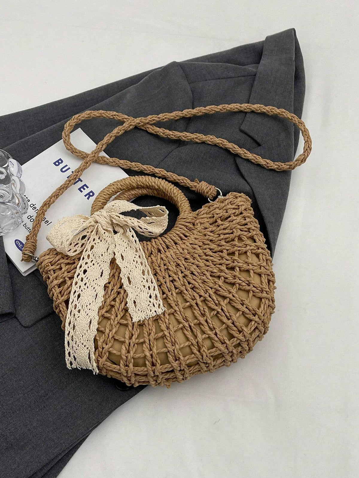 Stråtaske i beige liggende på strandmåtte