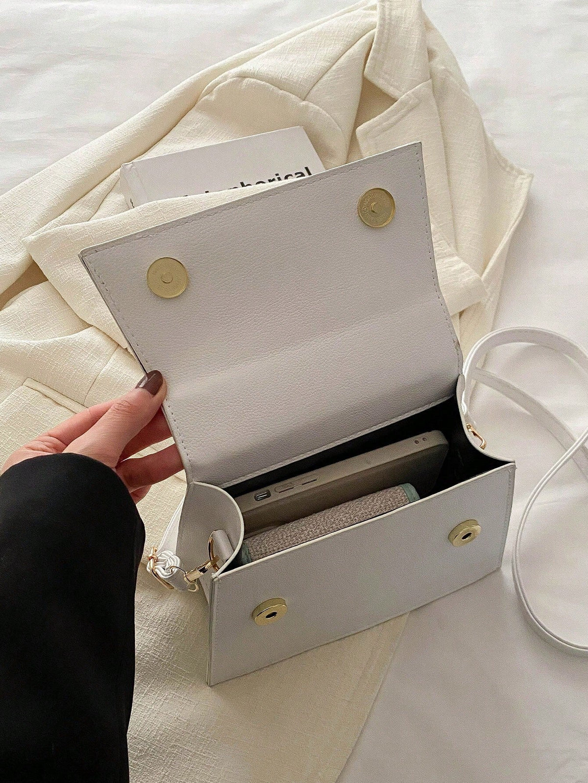 Detalje af flip-lukning på mini crossbody taske