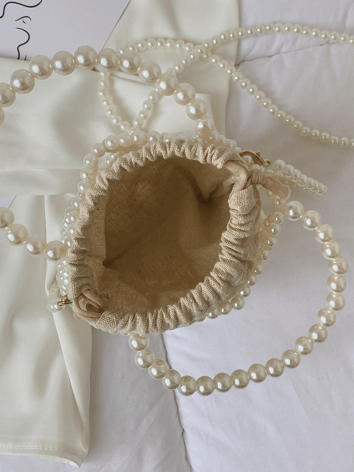 Perletaske placeret på bord – sommeraccessoire