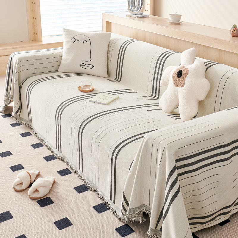 Sofabetræk i stripet chenille med kvaster på sofa i stue
