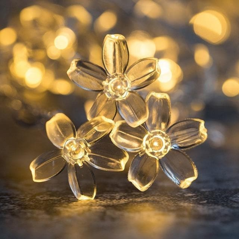 Nærbillede af dekorative blomsterlampeskærme på LED lyskæde