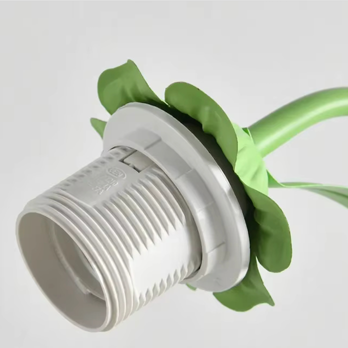 Bordlampe i blomsterdesign – vist i stue-/soveværelsesmiljø