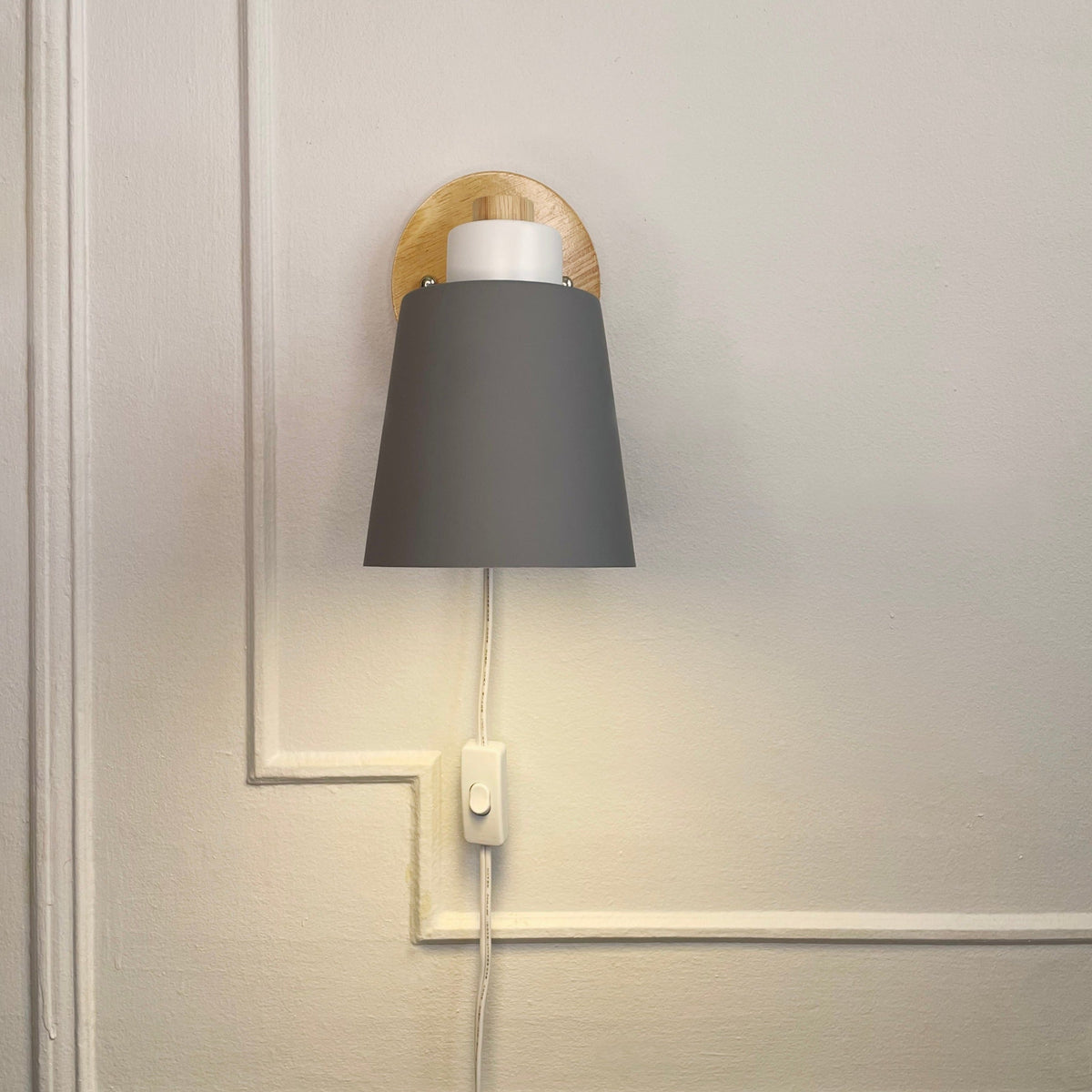 Væglampe med hvid metalskærm og træbagplade