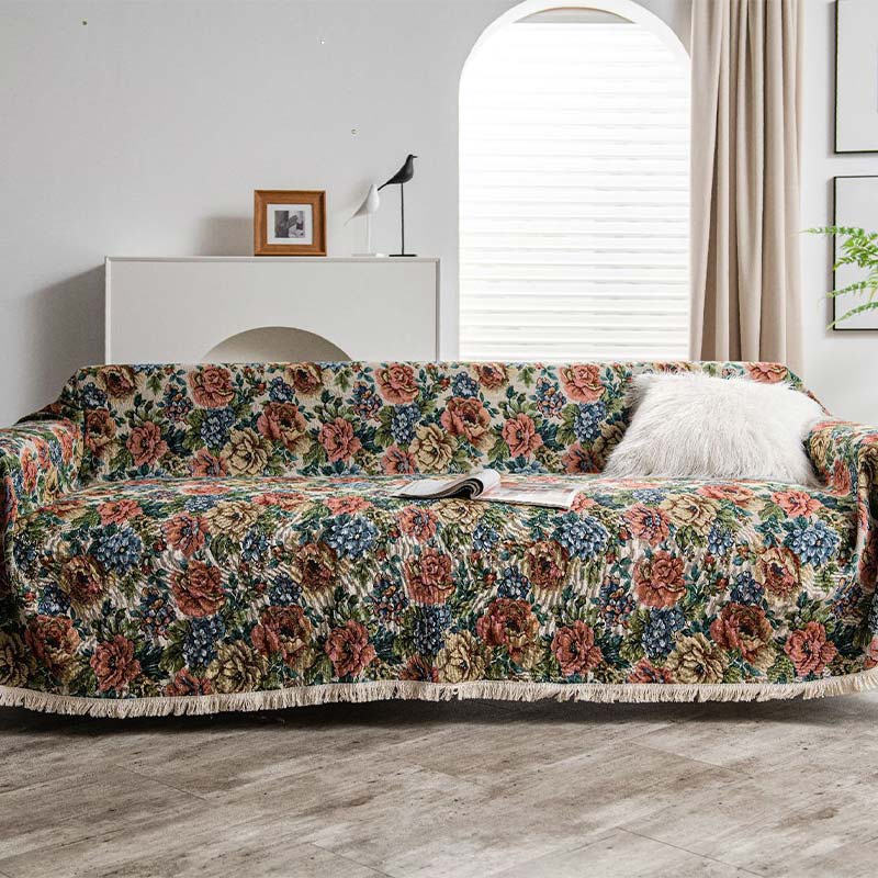 Sofabeskytter med rosenprint drapert over sofa i stue