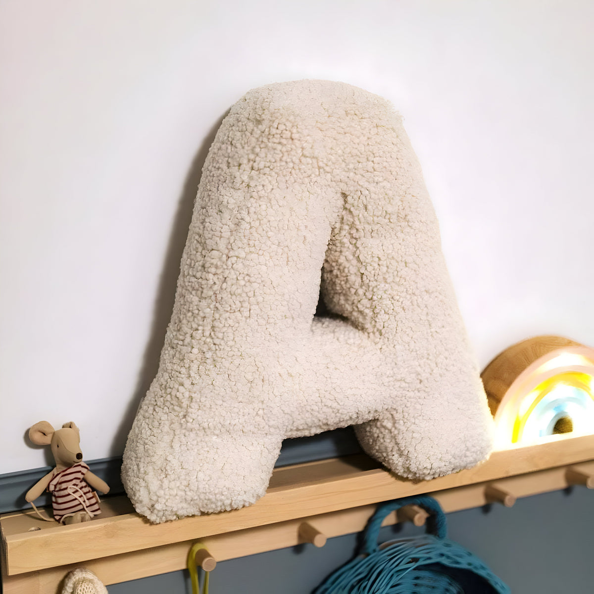 Blødt bogstavpude i beige plys til sofa og soveværelse