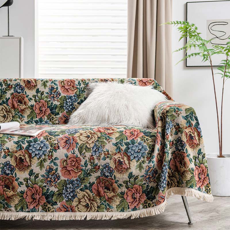 Sofacover med landligt rosenprint og kvaster på sofa